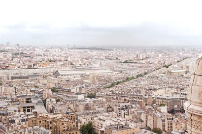 Travel essentials on a world map, including a camera, compass, and currency.

Cityscape of Paris with dense buildings under a cloudy sky. This alt text was added with Al; accuracy may vary.