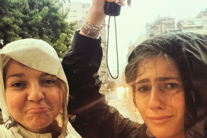 Two people with raincoats, holding keys, looking a bit damp and amused. This alt text was added with Al; accuracy may vary.