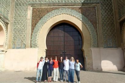 1. Tall stone tower with intricate architecture under a cloudy sky.
2. Christ figure in front of illuminated blue wall inside a church.
3. Group of people standing in front of a large, ornate arched gateway. This alt text was added with Al; accuracy may vary.