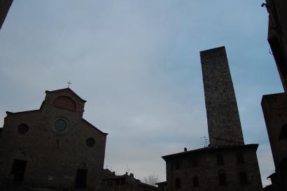 Rooftops of a European town with red tiles and chimneys under a hazy sky. This alt text was added with Al; accuracy may vary.