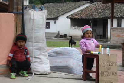 Two Ecuadorian children selling bug spray in a small town