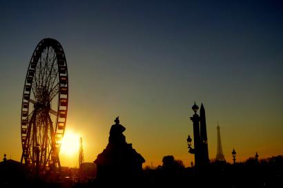 View through archway to gardens, a distant cityscape under a blue sky. This alt text was added with Al; accuracy may vary.