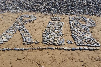 RIP made of stones on the beach of Omaha