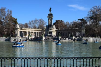 Man standing on a pipe over water, holding another's hand for balance. This alt text was added with Al; accuracy may vary.