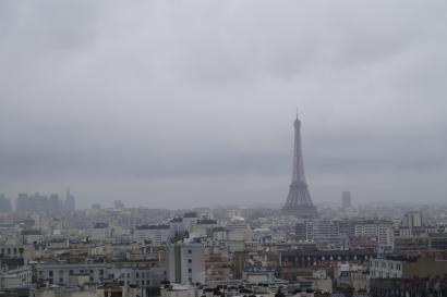Cloudy Paris skyline with Eiffel Tower in the distance. This alt text was added with Al; accuracy may vary.