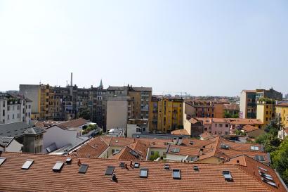 Purple bike on an Amsterdam canal bridge, with autumn trees and historic buildings. This alt text was added with Al; accuracy may vary.