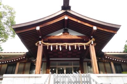 Traditional shrine with wooden beams and rope decoration. This alt text was added with Al; accuracy may vary.