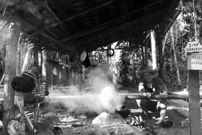Sandy path through trees with wooden fence and sign. This alt text was added with Al; accuracy may vary.