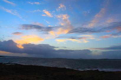 Rolling hills with stone wall under cloudy sky. This alt text was added with Al; accuracy may vary.
