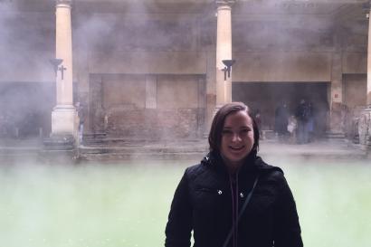 The author standing in front of pool of water at the ancient Roman baths in Bath, England