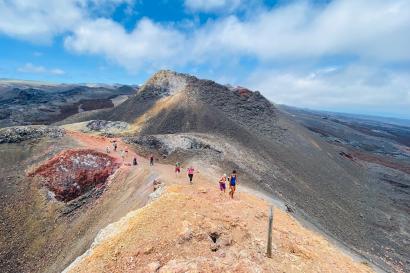 people walking alongside a large volcano