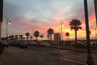 a sunset on a boulevard with palm trees