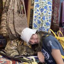 student cuddling cat in market