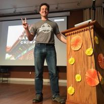 An Ambassador gives a presentation at a wood podium.