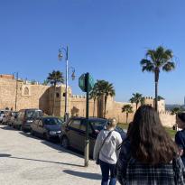 A view of students walking to the Kasbah, an ancient beige stone fortress