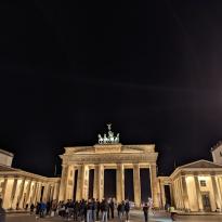Brandenburger Tor lit up at night with a crowd in front of it