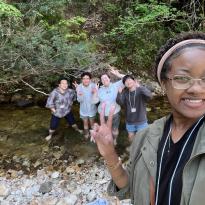 Author, Macks, posing with friends in a stream in they saw while hiking.