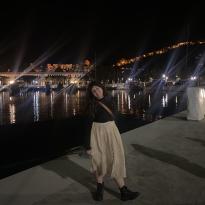 A girl standing at the port of Malaga at night