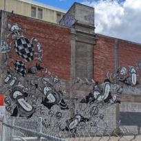 A mural of cartoon characters cascading across a brick wall