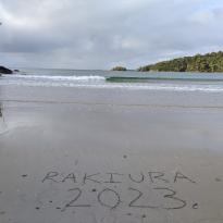 A beach with "Rakiura 2023" written in the sand