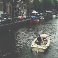 A faded photo of a boat in an Amsterdam Canal