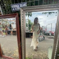 Mirror selfie in a flea market, young women in a dress