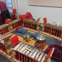 Red and gold xylophone-like instruments of different sizes with a small gong and chimes in the middle