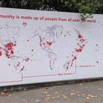 A large display featuring a map of the world with red stickers placed on where people at UC are from