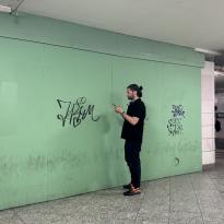 A man in black in front of a brightly colored u-bahn wall