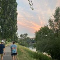 Two guys walking along the river at sunset