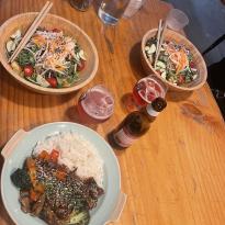 Image of two plates with salads & one plate with a rice dish at a restaurant  