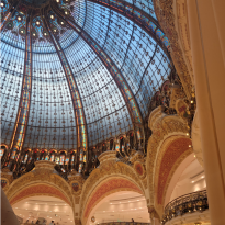 The glass dome inside of the shopping mall Galleries Lafayette that has small balconies on each level of the store to look into the center. 