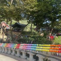 Bridge with multi-colored lanterns and traditional Korean building 