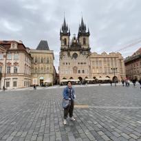Me (a short white man with a denim jacket and green pants) in the middle of Prague old town, surrounded by gothic buildings. It is in 0.5 view so I look smaller than I am.