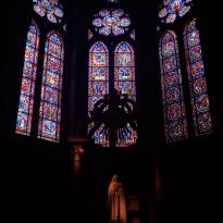A statue of the Virgin Mary sitting below stained-glass windows that are utterly magnificent.