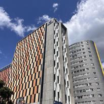 This photo shows an orange high rise building that houses students at University of Auckland.