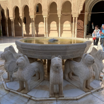 round fountain supported by marble lions