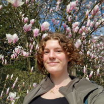A girl standing in front of a blooming Magnolia tree in Brussels. She is not nearly as beautiful as they are but she doesn't care.