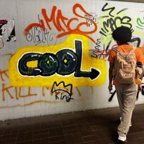 Person standing next to graffiti