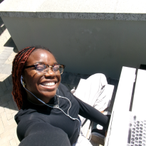 Picture of me smiling in the sun while studying outside the HPI d-school building. 