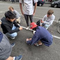 People on the sidewalk trying to open something