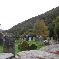 Gravestones and trees in front of mountains