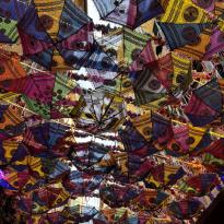 Mini Umbrellas hanging from buildings