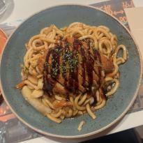 Plant-Based Chicken on top of stir-fried udon noodles and vegetables from UDON