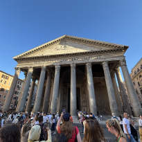 A frontal view of the Pantheon with tourists in the foreground