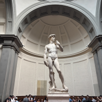 A large sculpture of a man with one hand raised and one hand at his side.