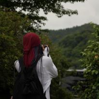 MJ Sails looking at a view in Osaka and taking a picture.