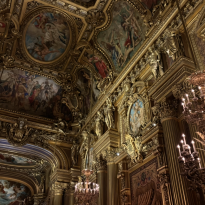 A room inside the Garnier Opera House with lots of paintings and gold features