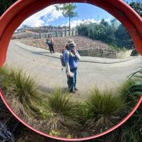 A selfie in the reflection of a fish eye mirror on the side of the Te Ara Hura trail.