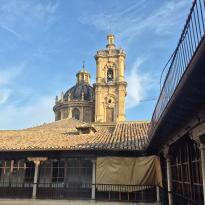 A church tower and dome in the background of an open courtyard
